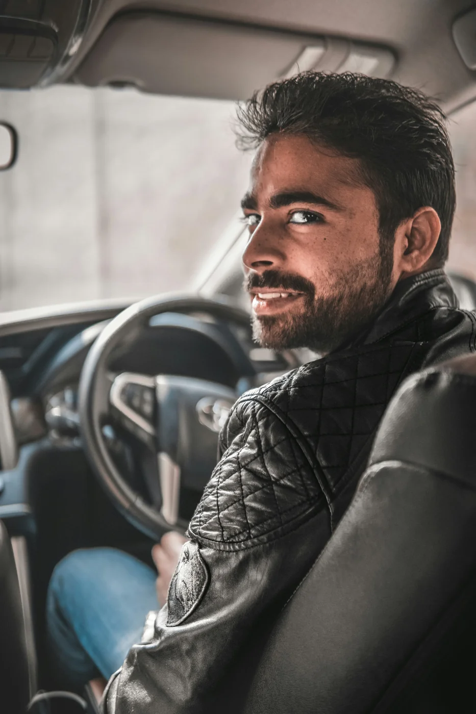 Motorista sorrindo no volante após regularizar a Carta com o Assistente do Condutor